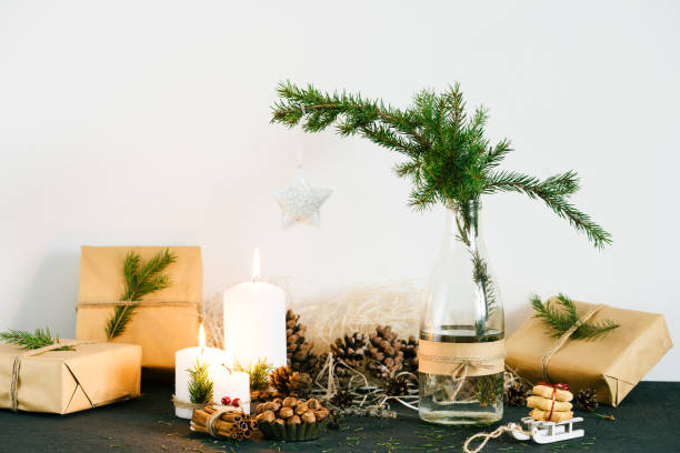 istock Christmas decorations with lit candles, gift boxes and spruce in the bottle on the table 830404816