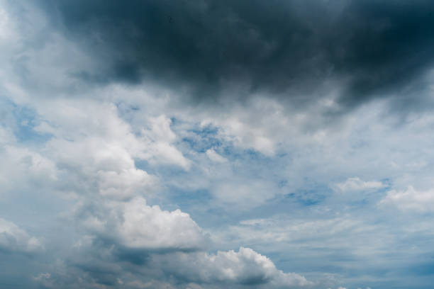 istock clouds with background,sunlight through very dark clouds background of dark storm clouds, black sky Background of dark clouds before a thunder. 830404968