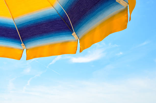 istock Colored sun umbrella, blue sky, outdoor, half close up 830405472