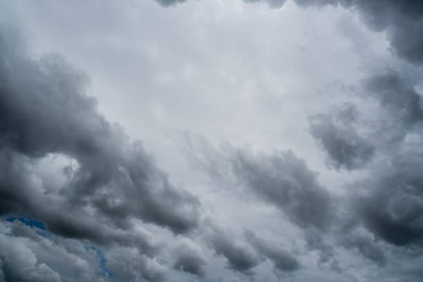 istock clouds with background,sunlight through very dark clouds background of dark storm clouds, black sky Background of dark clouds before a thunder. 830406370