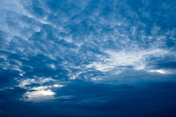 istock clouds with background,sunlight through very dark clouds background of dark storm clouds, black sky Background of dark clouds before a thunder. 830407148