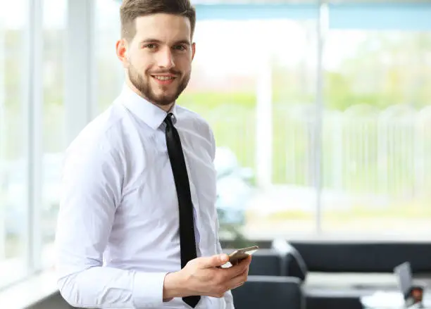 Photo of View of a Young attractive business man using smartphone.