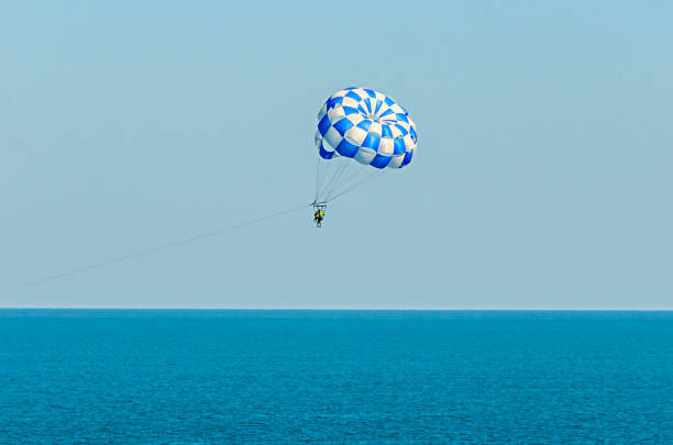 istock Blue parasail wing pulled by a boat in the sea water, Parasailing also known as parascending or parakiting 830419330