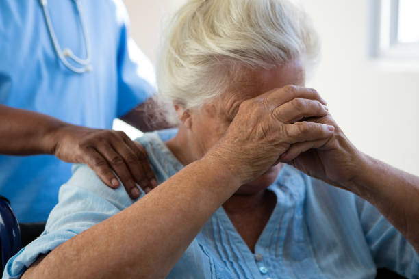 istock Nurse consoling senior woman at nursing home 830421982