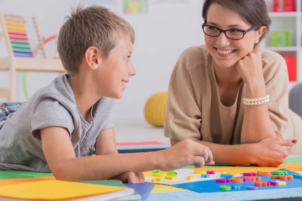 istock Blonde boy lying on floor with woman 830457774