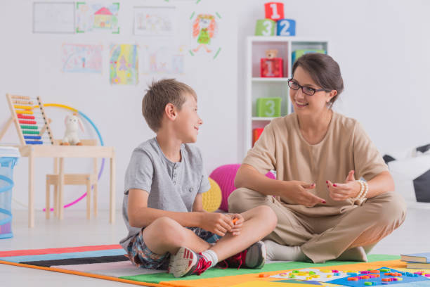 Boy and therapist sitting on floor