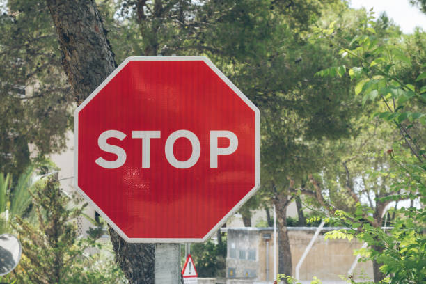 istock red stop sign at spain with green background 830464338