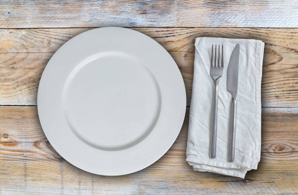 istock Empty plate with cutlery on untreated wood background 830473916
