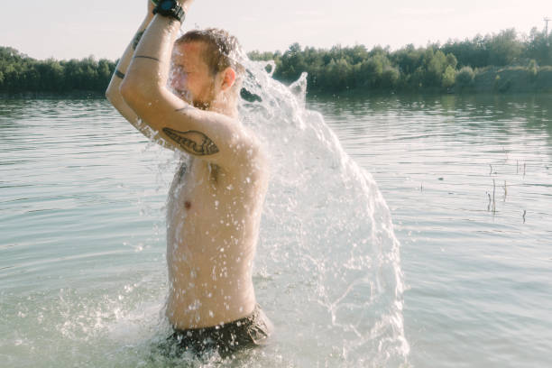 istock Man taking shower at lake from watermelon 830495418