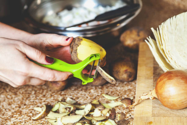 istock Cleaning potatoes. Woman's hands clean potatoes special tool 830496874