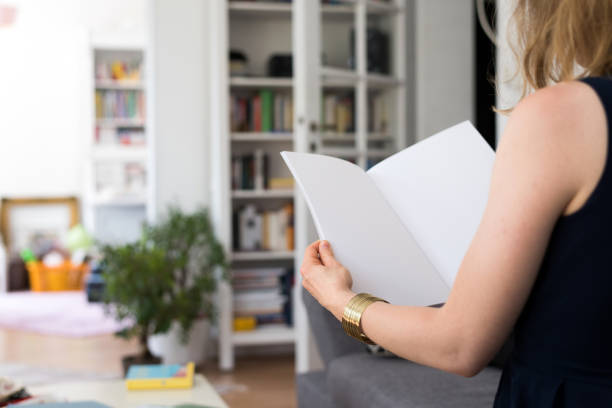 frau hält eine leere broschüre mit textfreiraum in ihren händen - newspaper reading holding paper stock-fotos und bilder