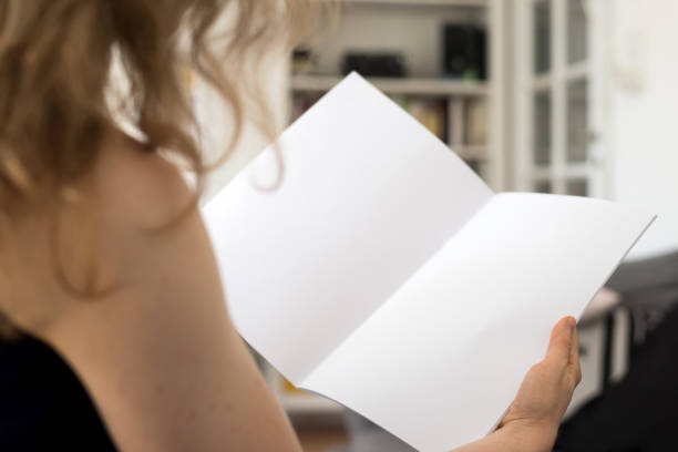 istock Woman holding a blank brochure with copy space in her hands 830531520