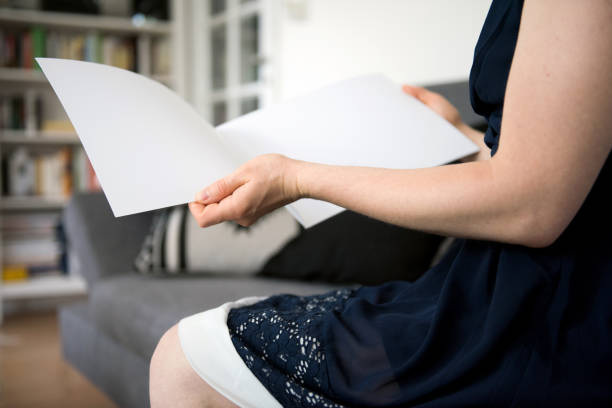 istock Woman holding a blank brochure with copy space in her hands 830531760