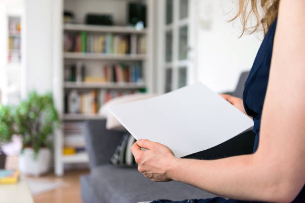 istock Woman holding a blank brochure with copy space in her hands 830531770
