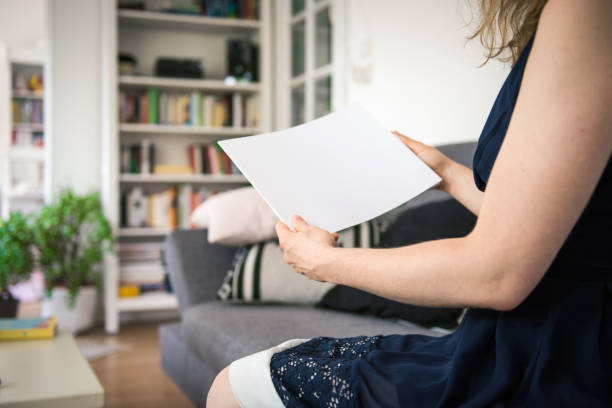 istock Woman holding a blank brochure with copy space in her hands 830532246