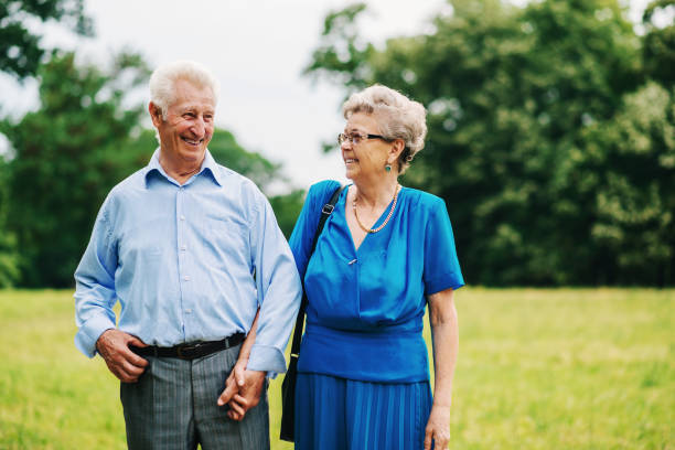 istock Senior married couple holding hands in park 830546702