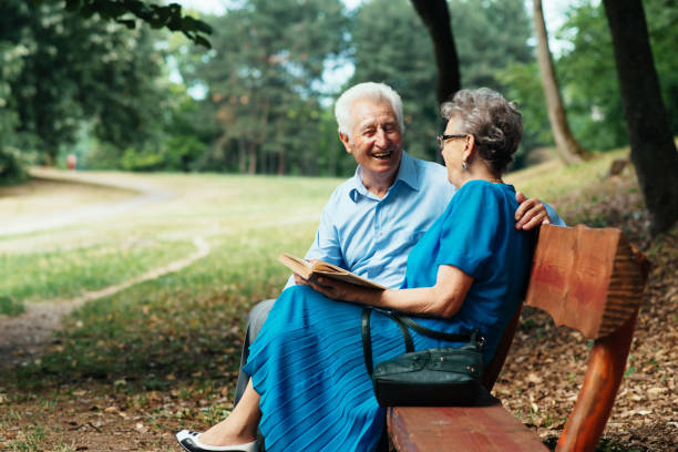 istock Seniors reading book in the park 830546854