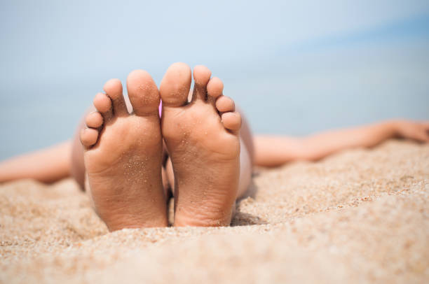istock Female feet on the sand. Lake Baikal 830546952