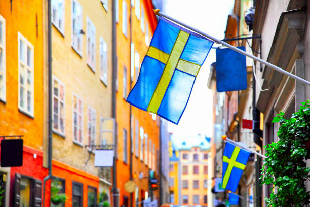 Street in Stockholm with swedish flags Old street in Stockholm with swedish flags, Sweden. Shallow DOF, focus on the first flag sweden stock pictures, royalty-free photos & images