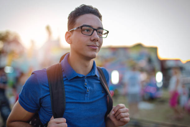 Nerd at amusement park Portrait of a 19 years old boy at amusement park. He comes here after school to meet with friends nerd teenager stock pictures, royalty-free photos & images