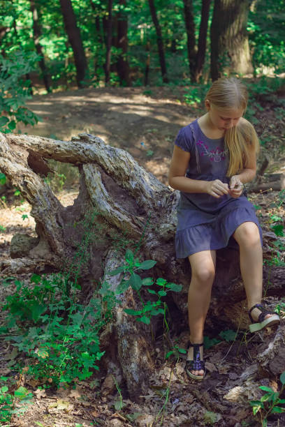 istock Girl sitting on a tree stump 830587396