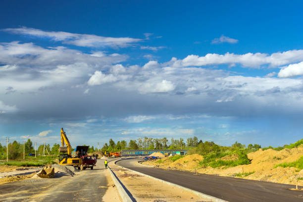 istock Excavator loads truck, construction bypass road 830637318