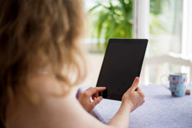 istock Woman looking at a digital tablet computer with blank screen and copy space 830642302