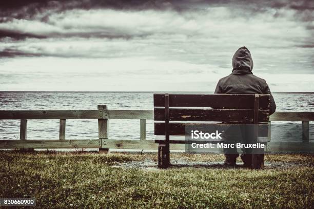 Man Sitting On Bench Overlooking Sea Stock Photo - Download Image Now - Depression - Sadness, Loneliness, One Person