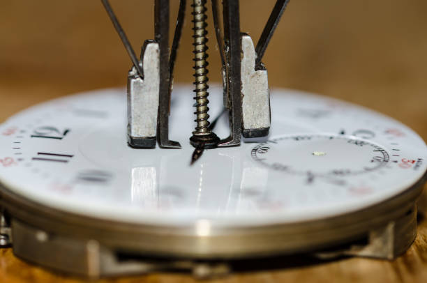 istock Watch Repair: Hands Remover About to Lift The Hands from a Pocket Watch Movement 830662320