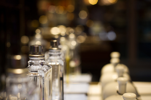 perspective view of white ceramic fragrance bells and perfume bottles in store shelf display with selective focus