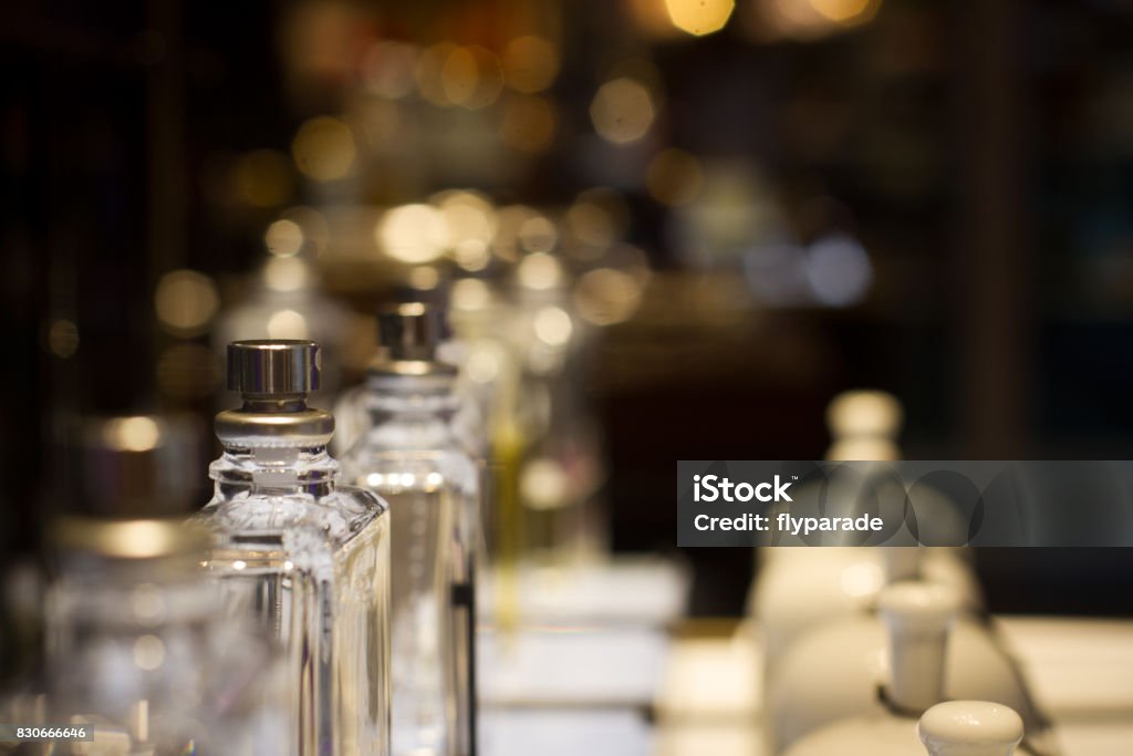 perfume bottles in store display shelf perspective view of white ceramic fragrance bells and perfume bottles in store shelf display with selective focus Perfume Stock Photo