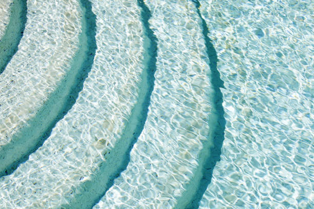 istock Sunlight and steps under the surface of swimming pool 830669992