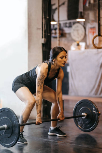istock Young woman lifting weights on cross training 830678408