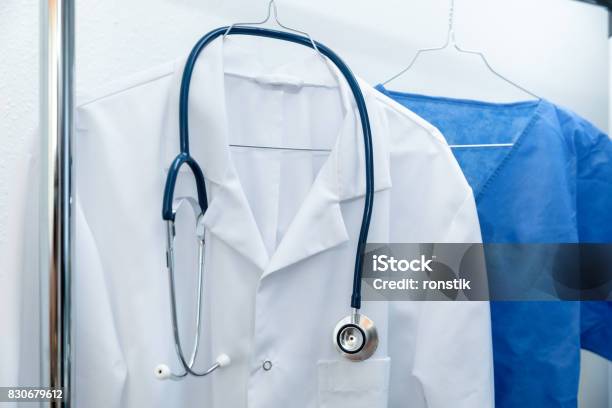 Medical Occupation Uniforms On Hanger Stock Photo - Download Image Now - Lab Coat, Coathanger, Hanging