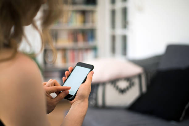 istock Woman is looking at a blank smart phone screen with copy space 830691464