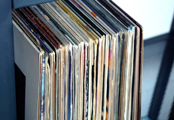 istock Stack of many vinyl records in old color covers on a shelf side view 830753894