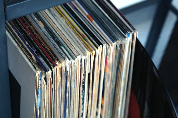 istock Stack of many vinyl records in old color covers on a shelf side view 830756236