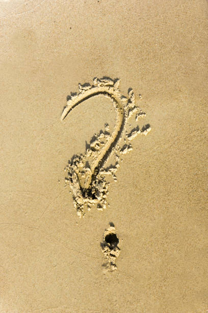 istock Question sign written in the sand on a sunset beach 830756874