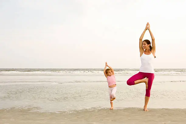 Photo of Mother teaches daughter yoga on beach