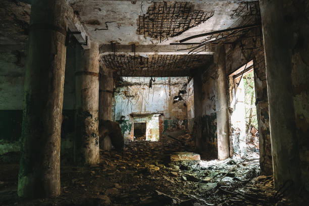 istock Dark hall of ruined abandoned factory with columns 830791400