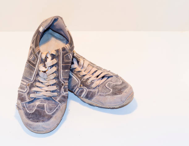 istock very old running shoes with laces on a light background. 830819556