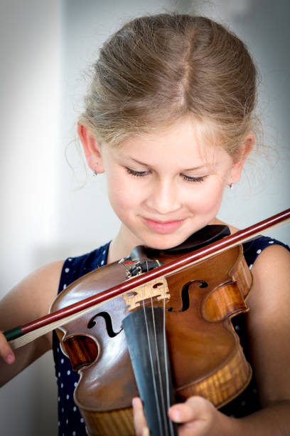 istock Young cute girl playing violin 830848956