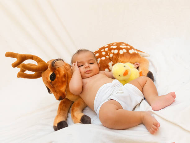istock 4 months old baby boy playing with soft toy dear and chick 830856908