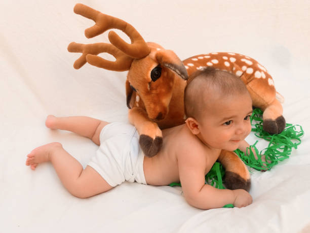 istock 4 months old baby boy playing with soft toy dear and chick 830857200