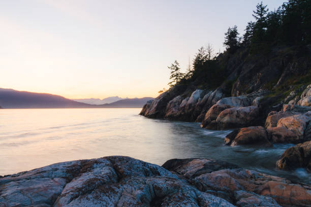 istock Sunset on coast with cliffs and mountains in background 830857874