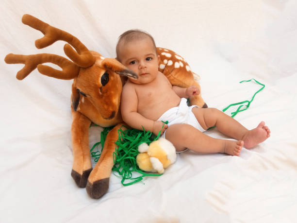 istock 4 months old baby boy playing with soft toy dear and chick 830858188