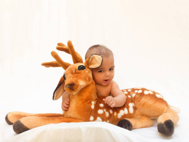 istock 4 months old baby boy playing with soft toy dear and chick 830858768