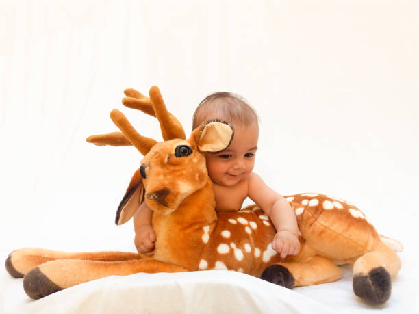 istock 4 months old baby boy playing with soft toy dear and chick 830858890