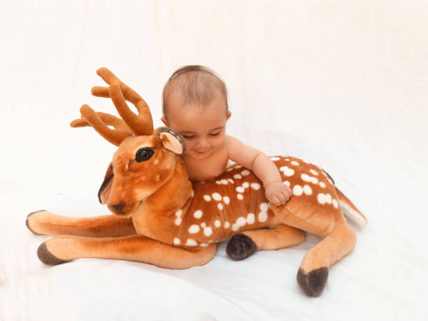 istock 4 months old baby boy playing with soft toy dear and chick 830858978