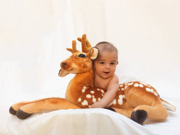 istock 4 months old baby boy playing with soft toy dear and chick 830859126
